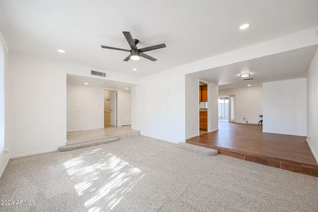 a view of empty room with wooden floor and a window