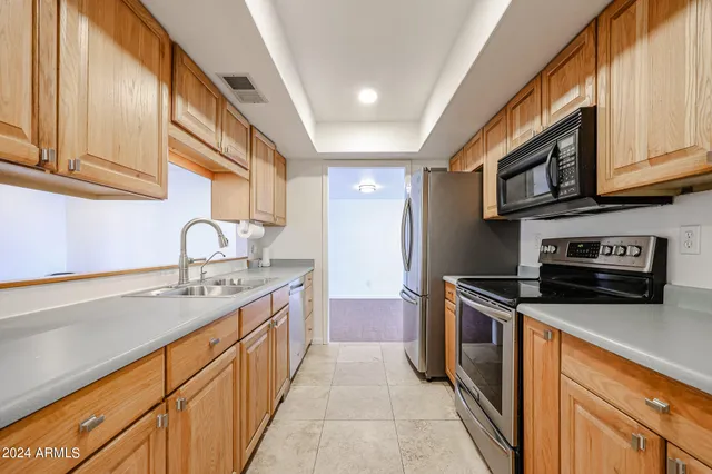 a kitchen with stainless steel appliances granite countertop a sink stove and cabinets