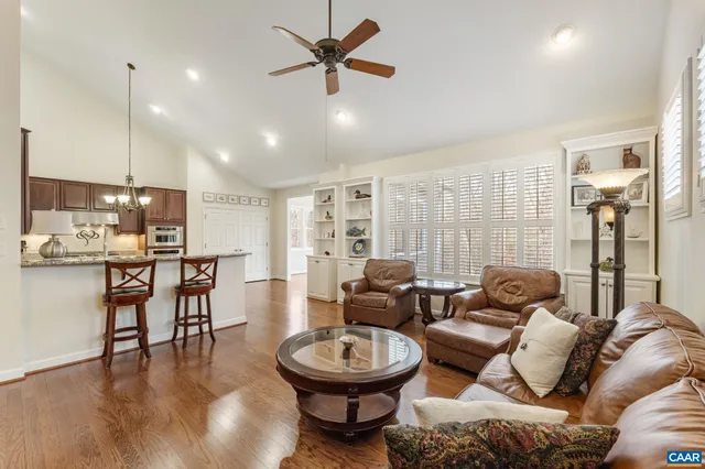 a living room with furniture a fireplace a flat screen tv and a large window