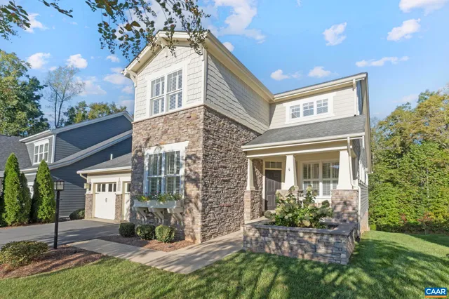 a view of a white house with a big yard and potted plants