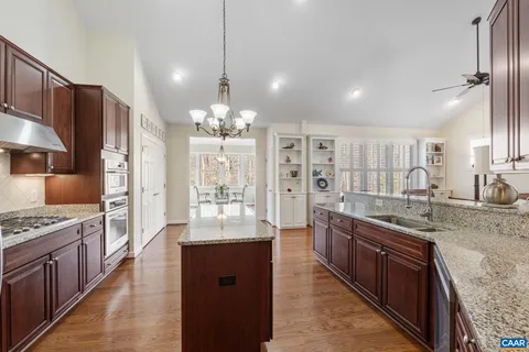 a dining room with furniture a chandelier and wooden floor