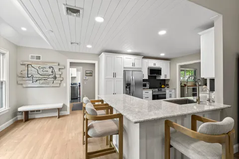 a kitchen with stainless steel appliances granite countertop a stove a sink and a microwave