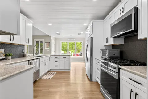 a kitchen with granite countertop white cabinets and appliances