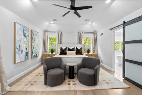 a bedroom with a bed window and a flat screen tv