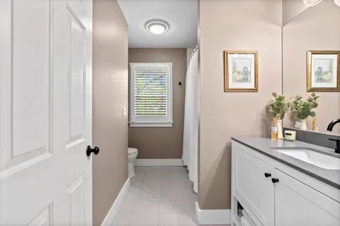a bathroom with a granite countertop sink a large mirror and a window