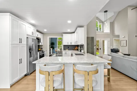 a living room with stainless steel appliances kitchen island granite countertop furniture and a kitchen view