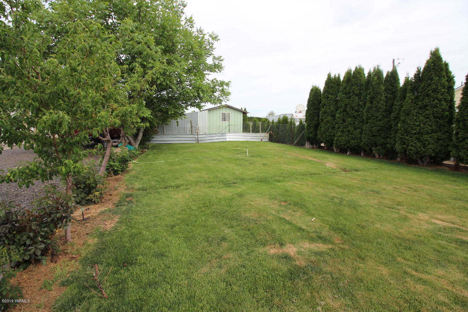 1615 Beaudry Road Yakima, WA 98901 - Photo 20 of 23 a view of a tiny house with a yard and trees