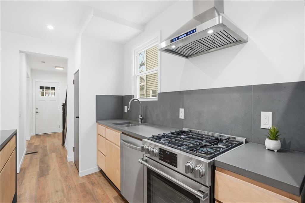 1402 Dickson Street Pittsburgh, PA 15212 - Photo 11 of 25 a kitchen with a stove and a wooden floor