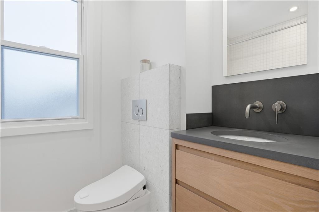 1402 Dickson Street Pittsburgh, PA 15212 - Photo 15 of 25 a bathroom with a toilet sink and mirror