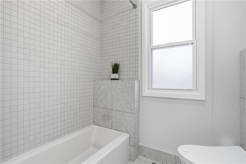 1402 Dickson Street Pittsburgh, PA 15212 - Photo 16 of 25 a bathroom with a toilet and a bathtub