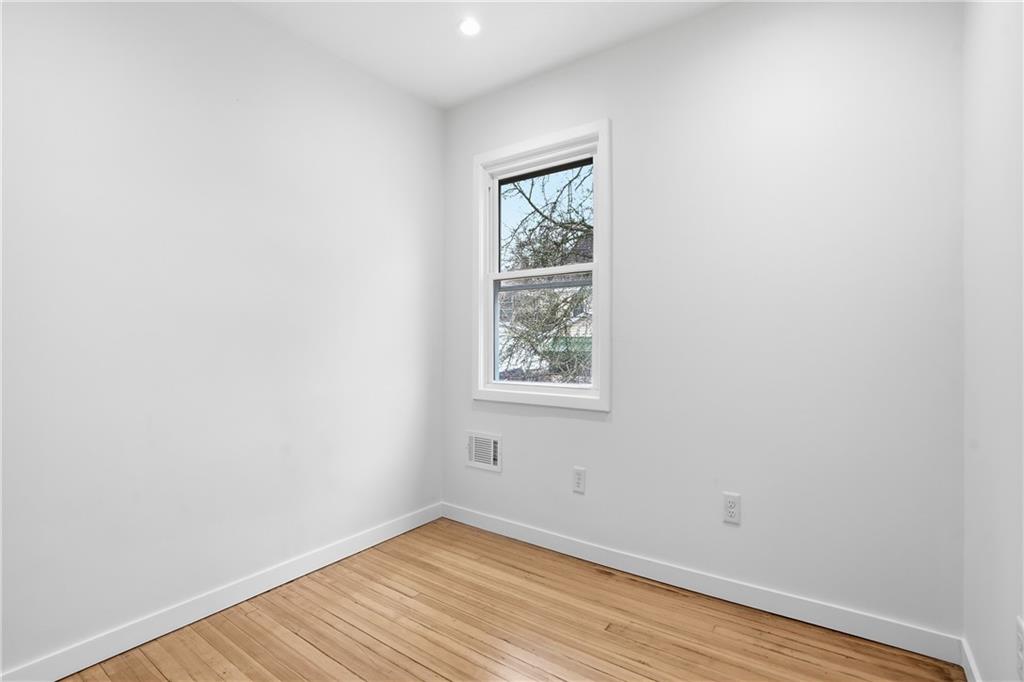 1402 Dickson Street Pittsburgh, PA 15212 - Photo 21 of 25 an empty room with wooden floor and windows