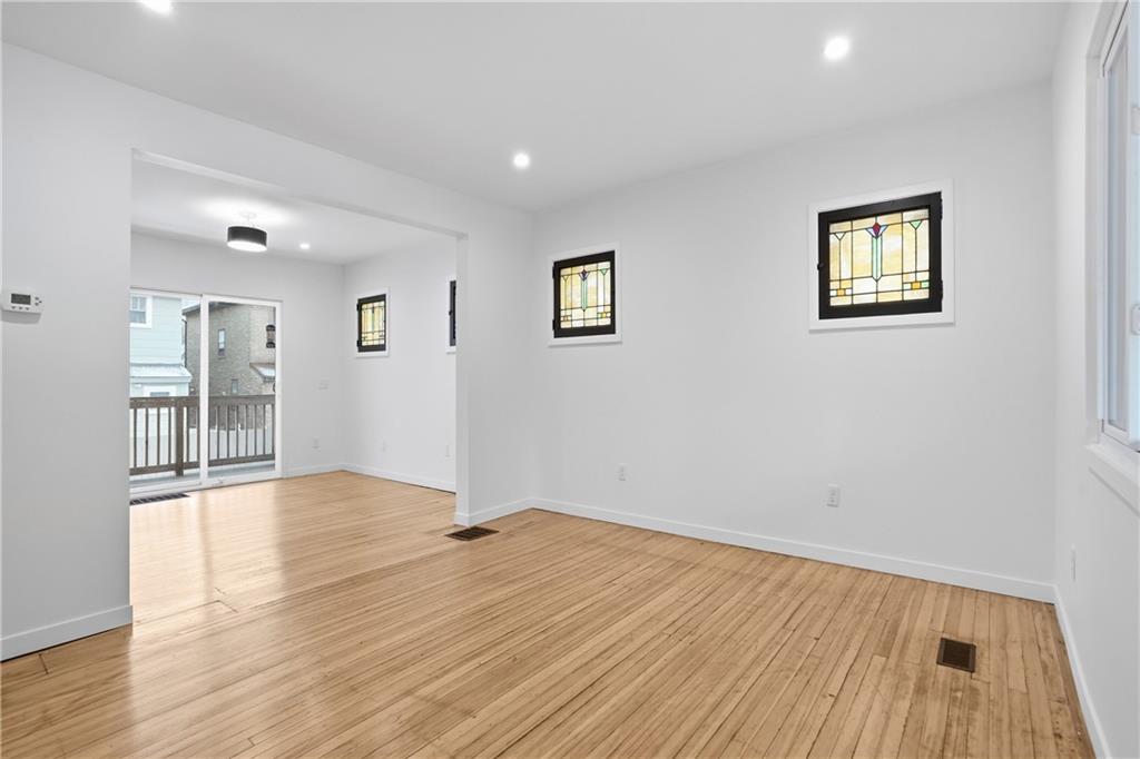 1402 Dickson Street Pittsburgh, PA 15212 - Photo 5 of 25 a view of an empty room with wooden floor and a window