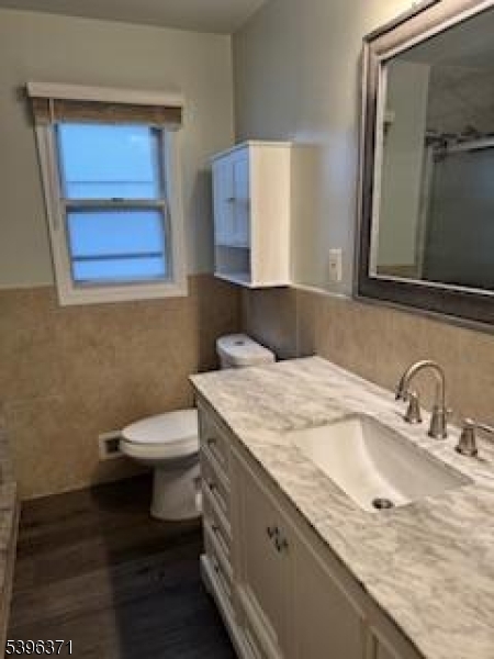 12 Pasadena Avenue Lodi, NJ 07644 - Photo 4 of 10 a bathroom with a granite countertop sink and a toilet