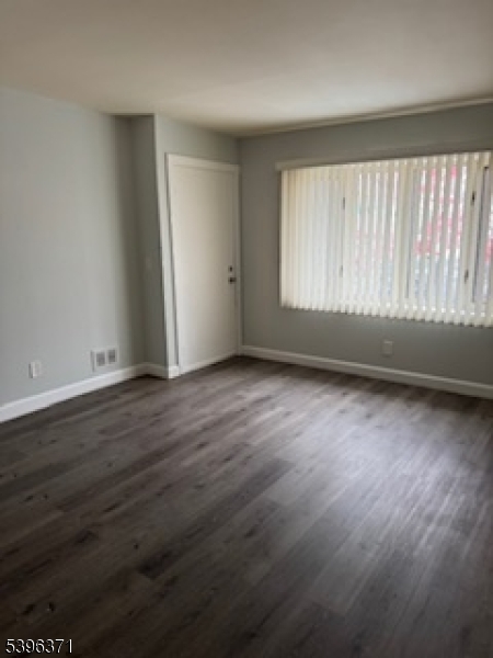 12 Pasadena Avenue Lodi, NJ 07644 - Photo 6 of 10 an empty room with wooden floor and windows