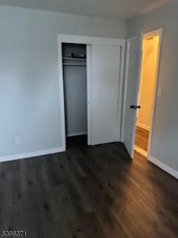 an empty room with wooden floor and closet
