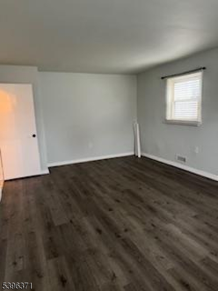 12 Pasadena Avenue Lodi, NJ 07644 - Photo 9 of 10 a view of an empty room with wooden floor and a window