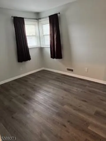 an empty room with wooden floor and window