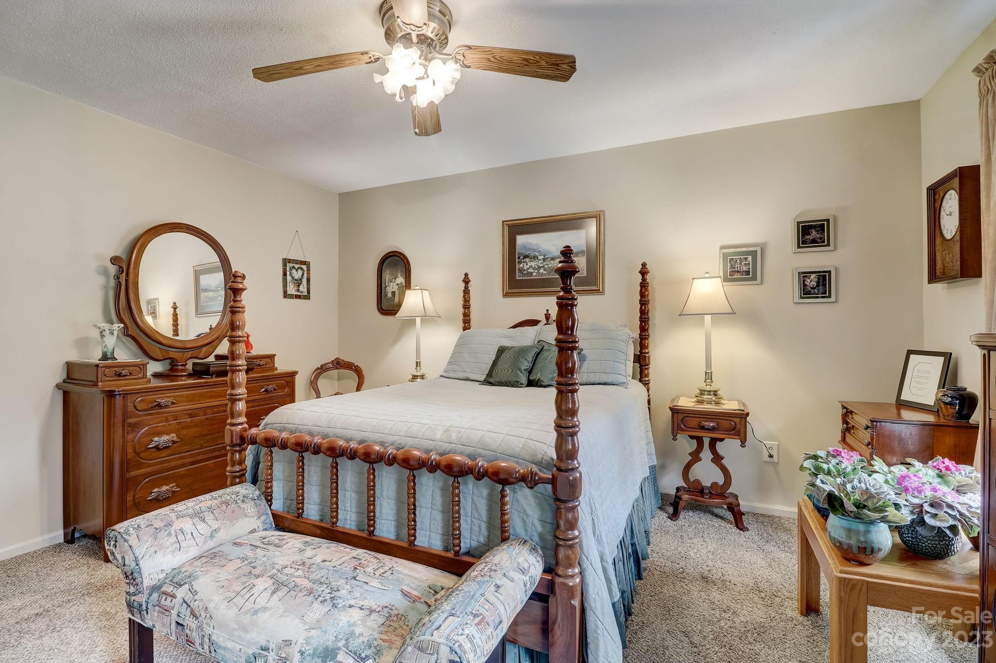 4 Bramblewood Road, Unit 8 Arden, NC 28704 - Photo 14 of 25 a bedroom with a bed a chandelier and dresser