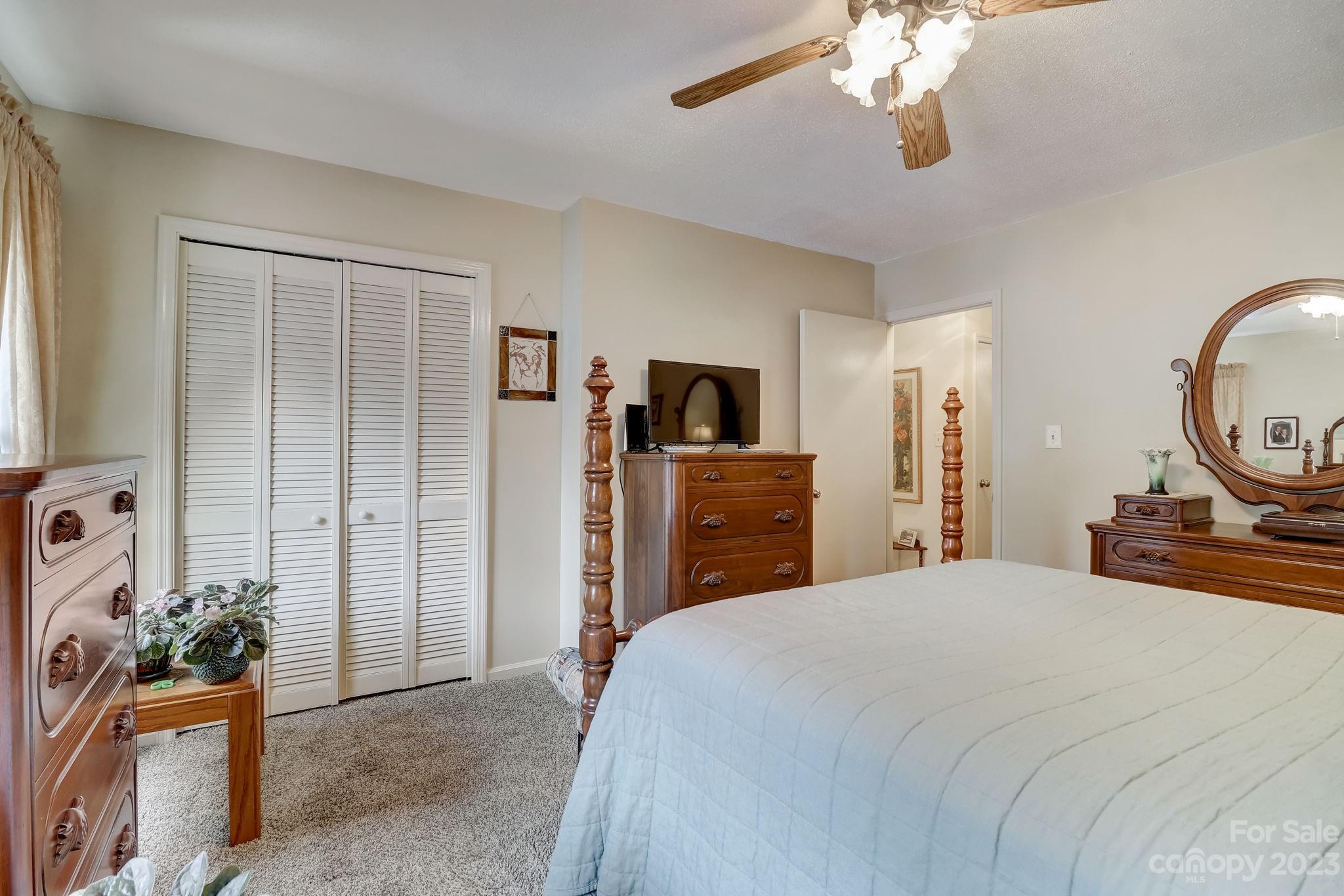 4 Bramblewood Road, Unit 8 Arden, NC 28704 - Photo 15 of 25 a bedroom with a bed and a chandelier