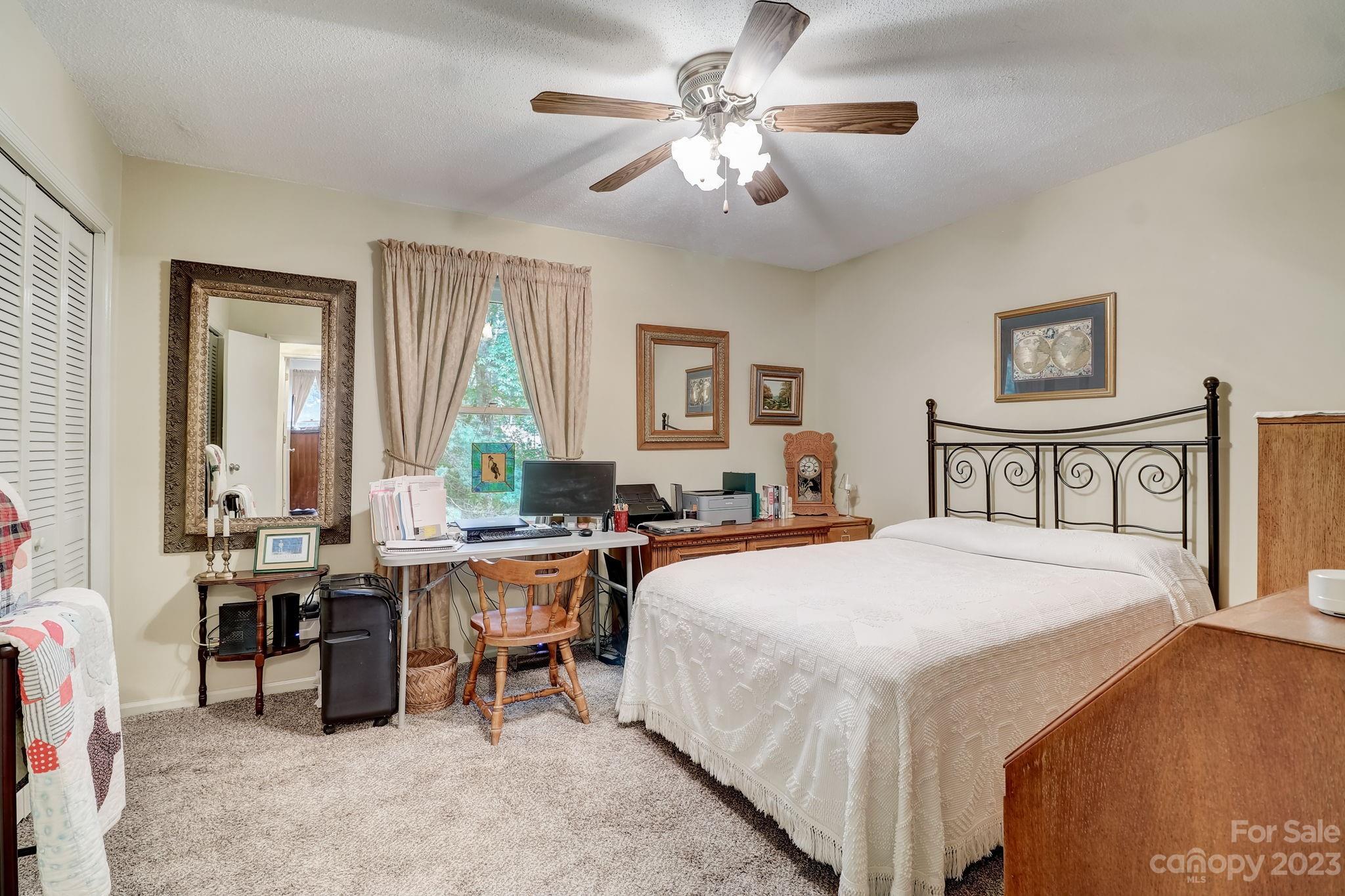 4 Bramblewood Road, Unit 8 Arden, NC 28704 - Photo 16 of 25 a bedroom with a bed and a chandelier