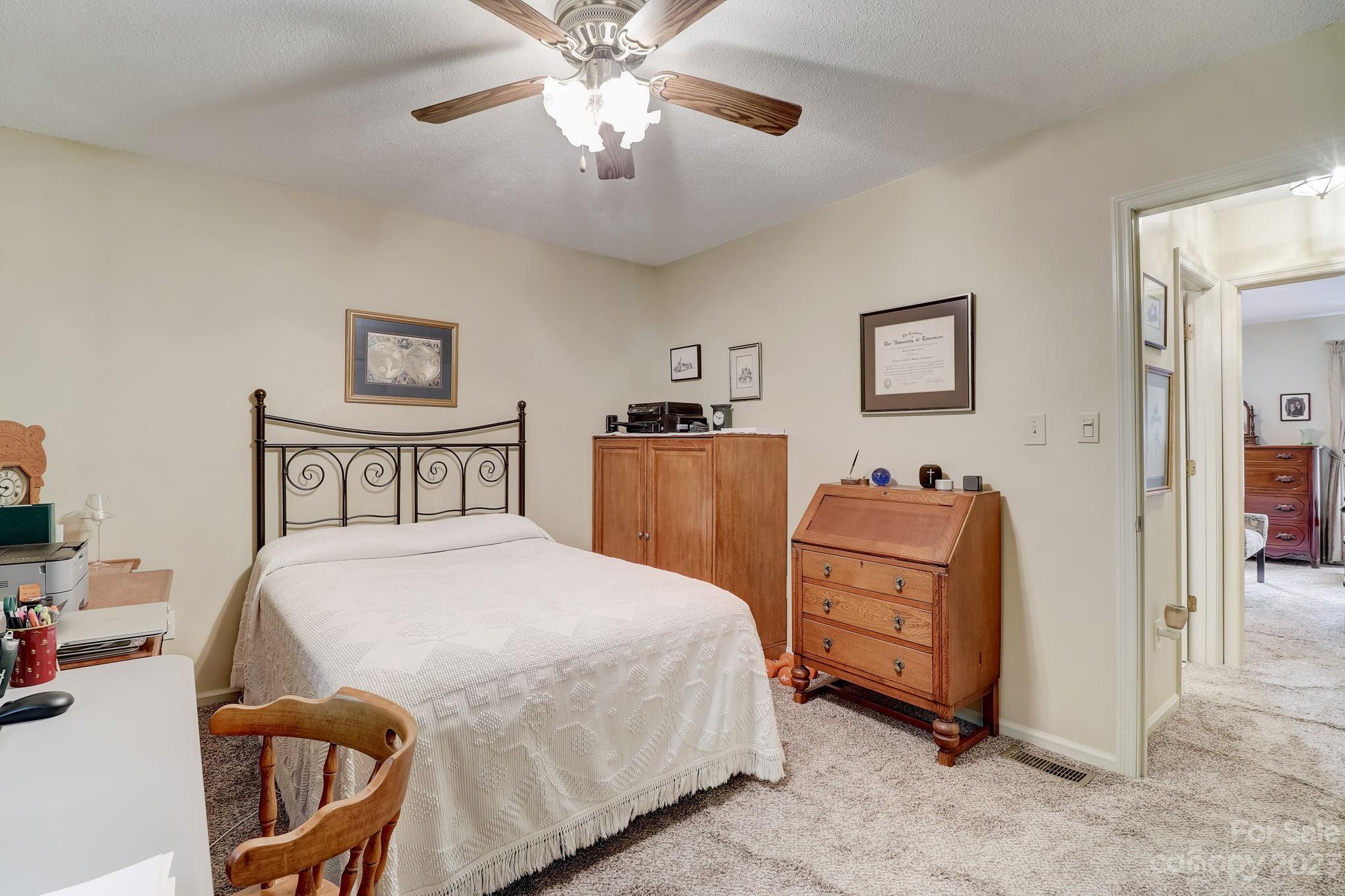 4 Bramblewood Road, Unit 8 Arden, NC 28704 - Photo 18 of 25 a bedroom with a bed and a chandelier