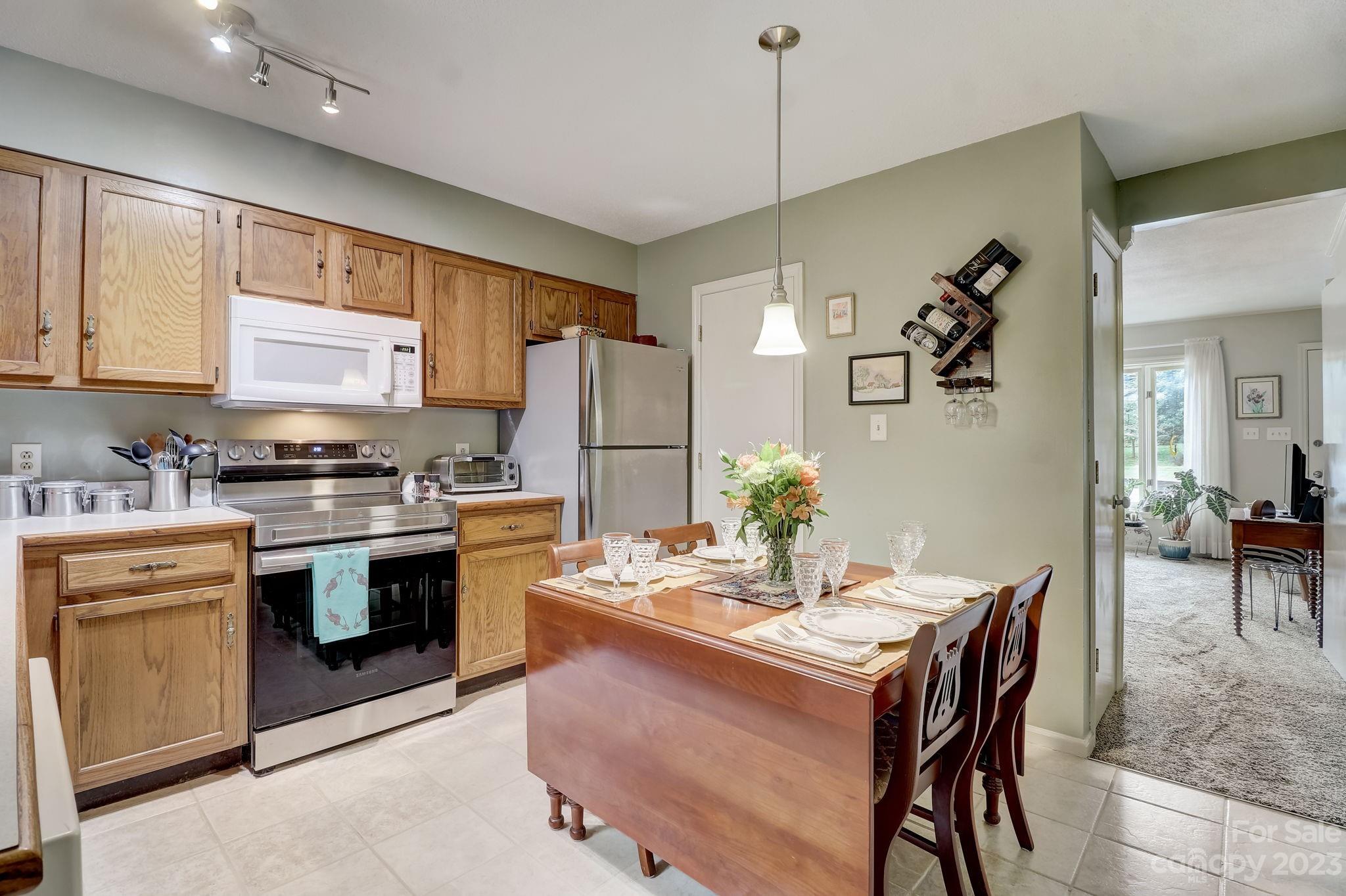 4 Bramblewood Road, Unit 8 Arden, NC 28704 - Photo 9 of 25 a kitchen with a refrigerator a stove a sink a dining table and chairs