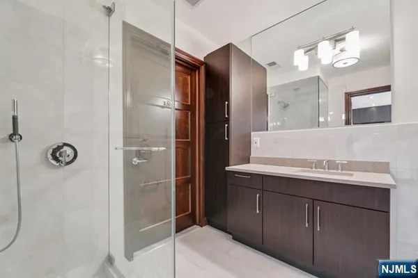 a bathroom with a sink a mirror a vanity and shower