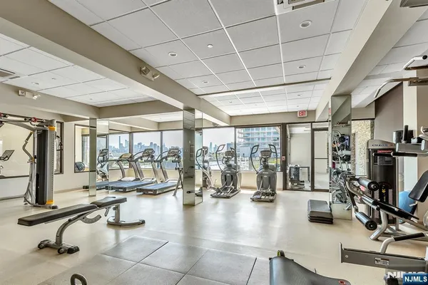 a room with gym equipment and large glass windows