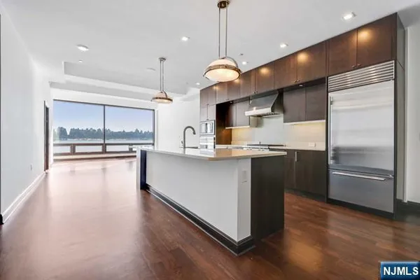 a kitchen with kitchen island a counter top space stainless steel appliances and a large window