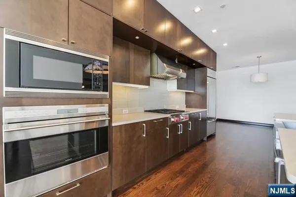 a kitchen with stainless steel appliances kitchen island wooden cabinets and granite counter tops