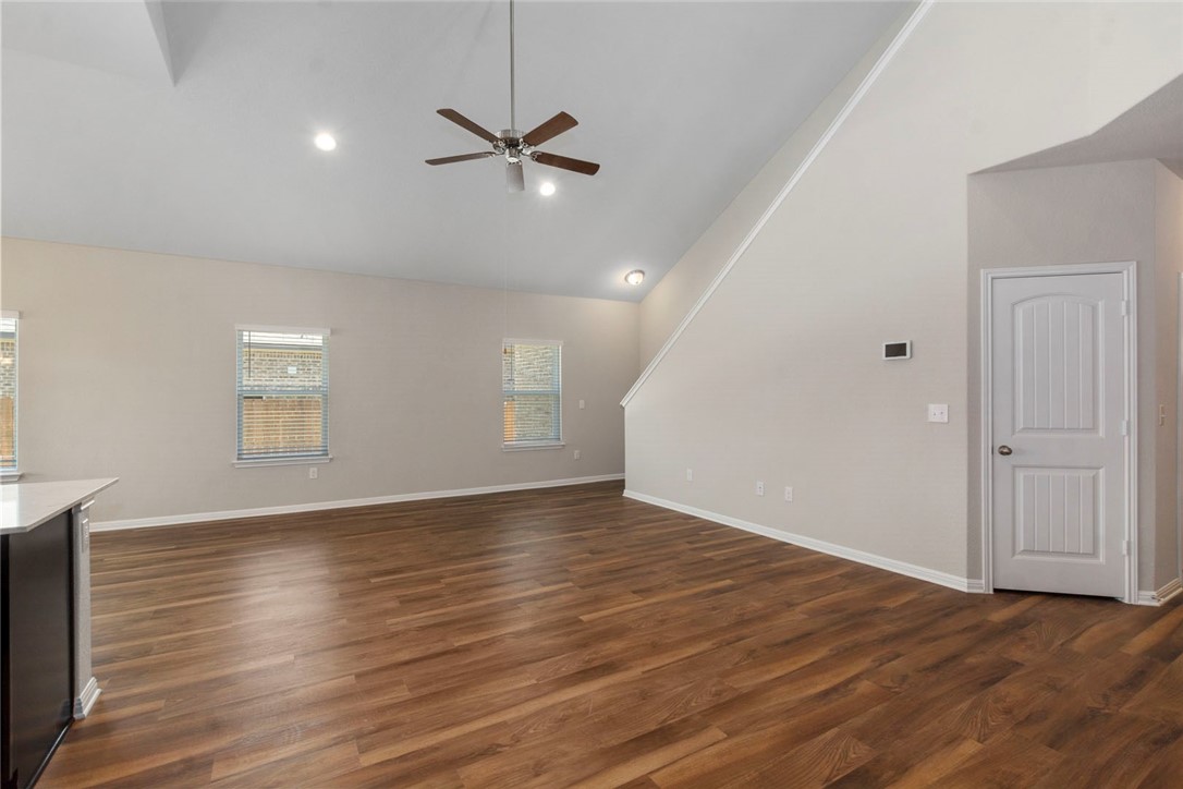 4217 Porter Farm Road Georgetown, TX 78628 - Photo 6 of 17 an empty room with wooden floor ceiling fan and windows