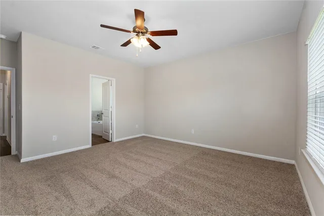 an empty room with a window and a fan