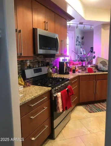 a kitchen with stainless steel appliances granite countertop a stove top oven and sink