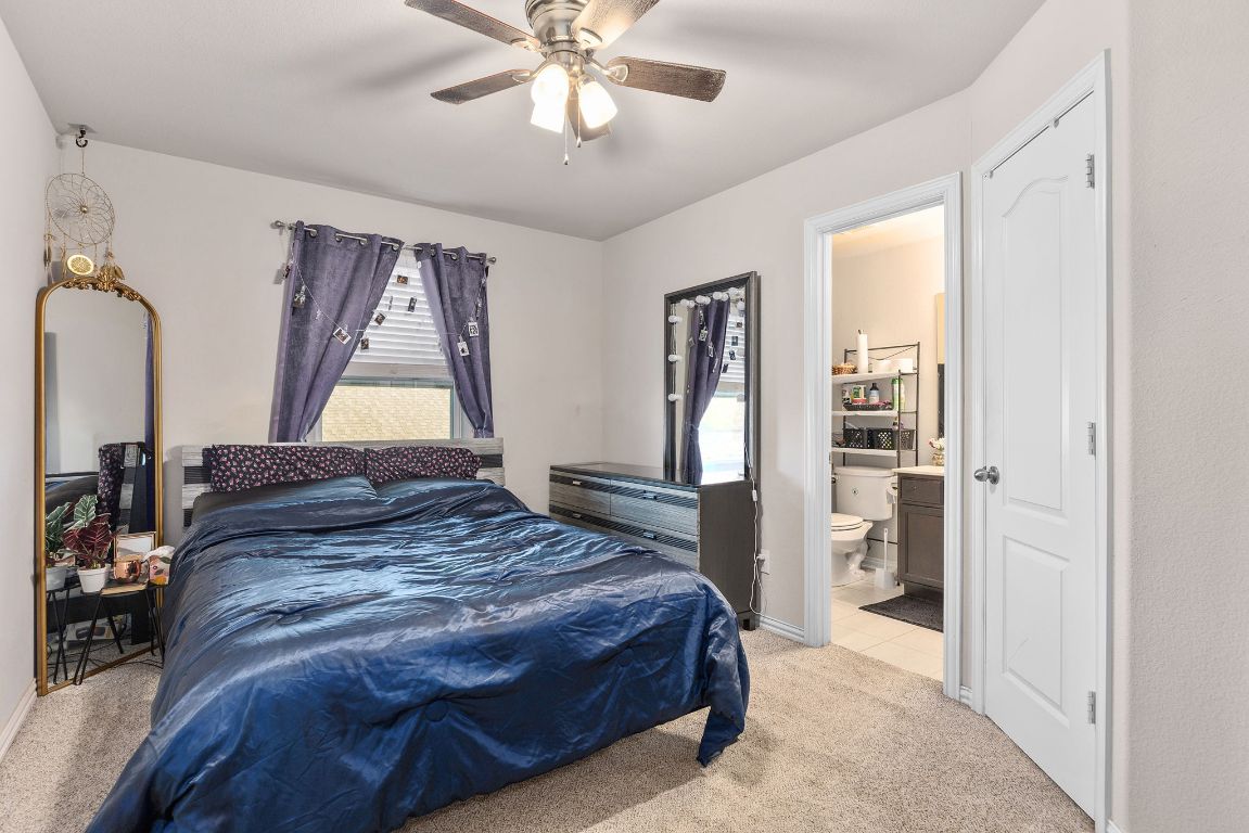 5925 Parma Street Round Rock, TX 78665 - Photo 20 of 36 Bedroom with light carpet, ceiling fan, and ensuite bathroom