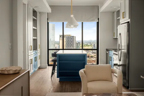 a living room with furniture and a floor to ceiling window