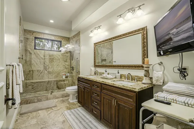a living room with furniture kitchen view and a chandelier