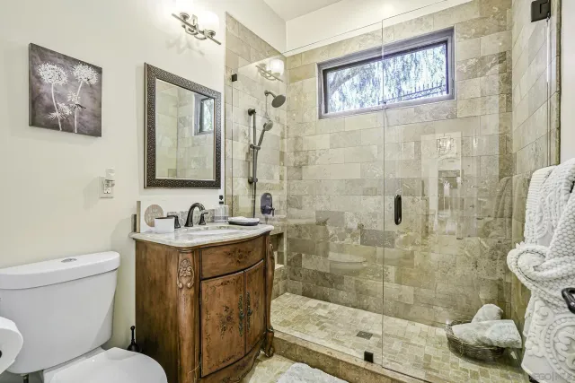a bedroom with a bed flat screen tv and a chandelier