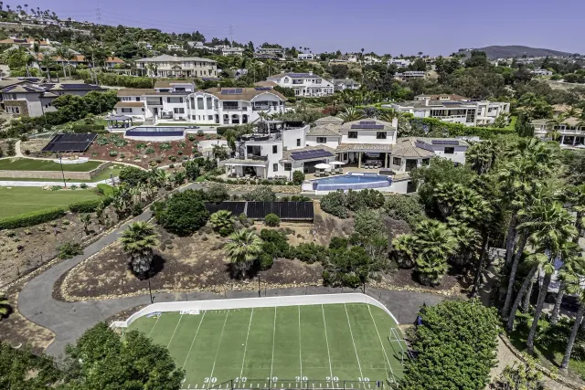 an aerial view of a house with outdoor space and a lake view in back
