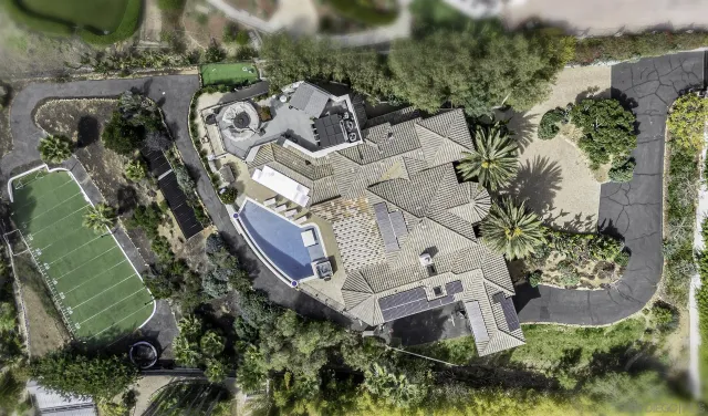 an aerial view of a house with a mountain