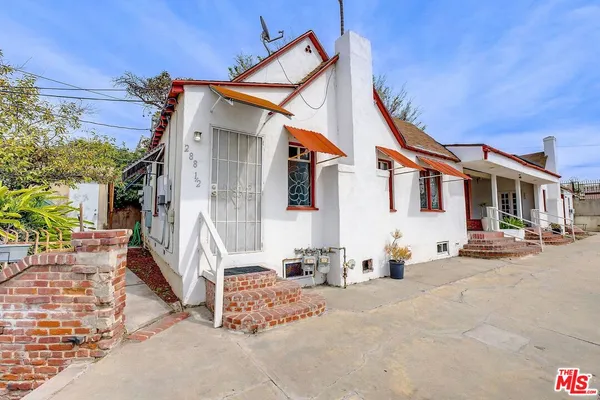 a view of a house with backyard and sitting area