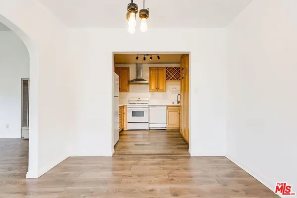 a view of kitchen with wooden floor and electronic appliances