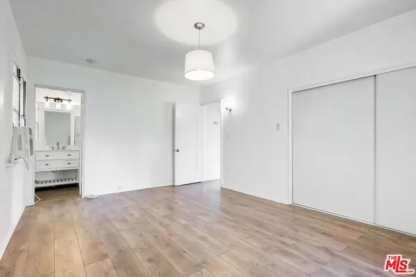 an empty room with wooden floor and mirror