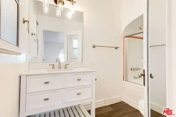 a bathroom with a sink a mirror a vanity and shower