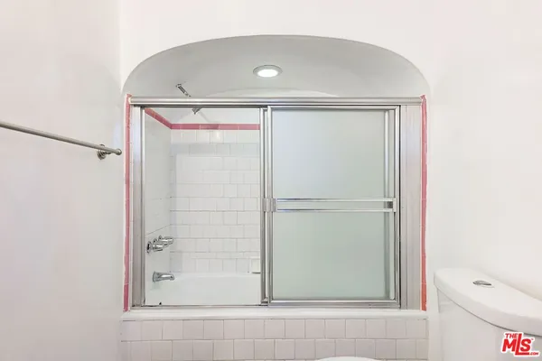 a view of a hallway with wooden floor and cabinet