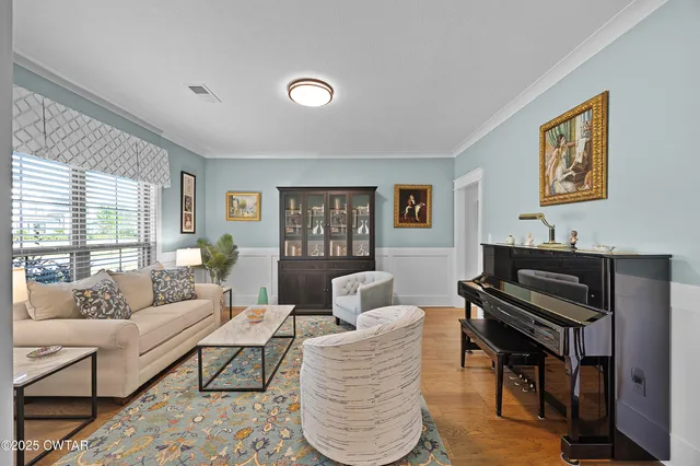 a living room with furniture piano and a window