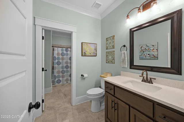 a bathroom with a toilet a sink a mirror and a shower