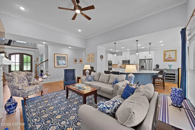 a living room with furniture and a view of kitchen