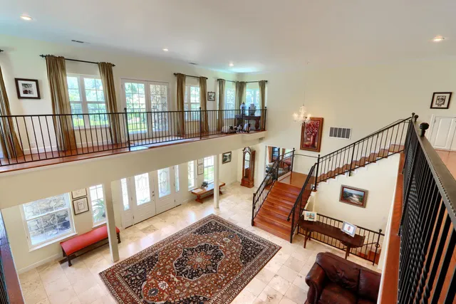 a living room with stainless steel appliances furniture a fireplace and wooden cabinets