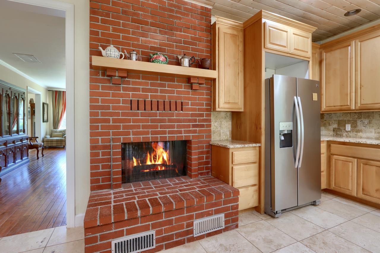 7551 Hunters Valley Road Mariposa, CA 95338 - Photo 21 of 78 a living room with stainless steel appliances furniture a fireplace and wooden cabinets