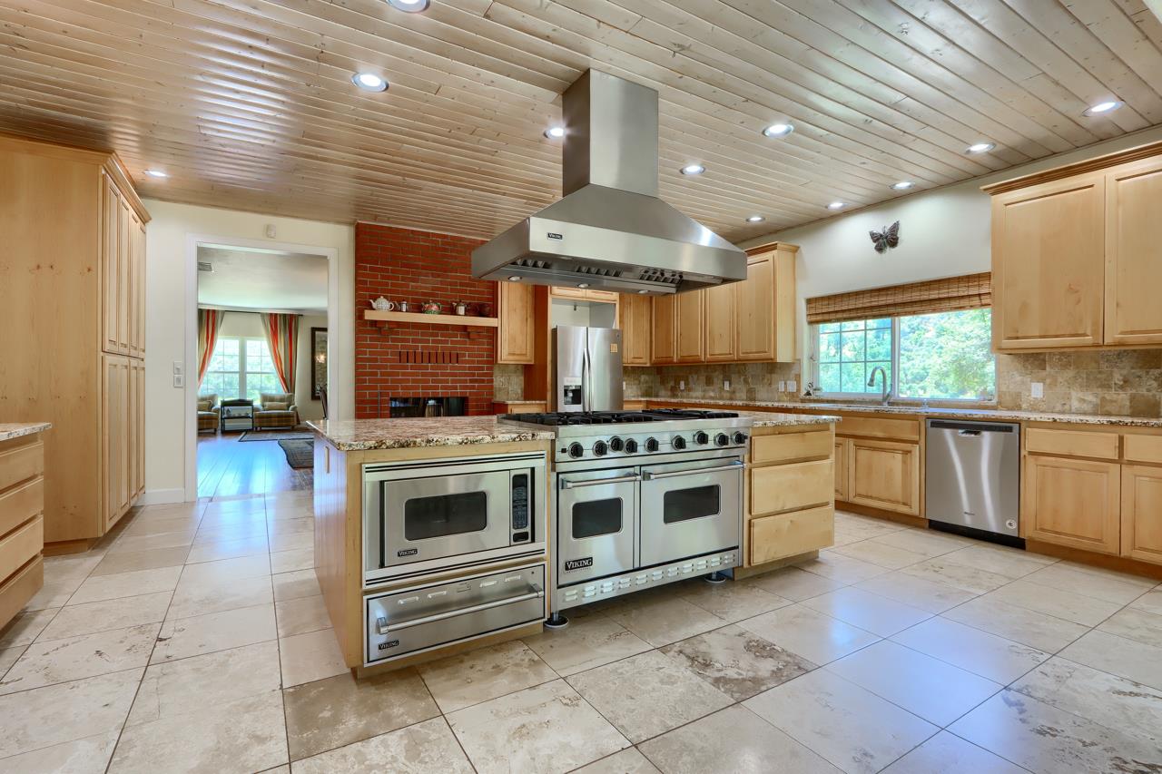 7551 Hunters Valley Road Mariposa, CA 95338 - Photo 24 of 78 a kitchen with stainless steel appliances granite countertop a stove a sink and a refrigerator